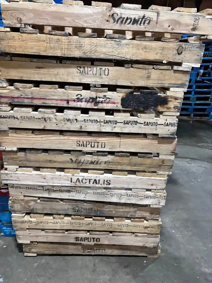 Warehouse worker inspecting used wood pallets for sale in Edmonton